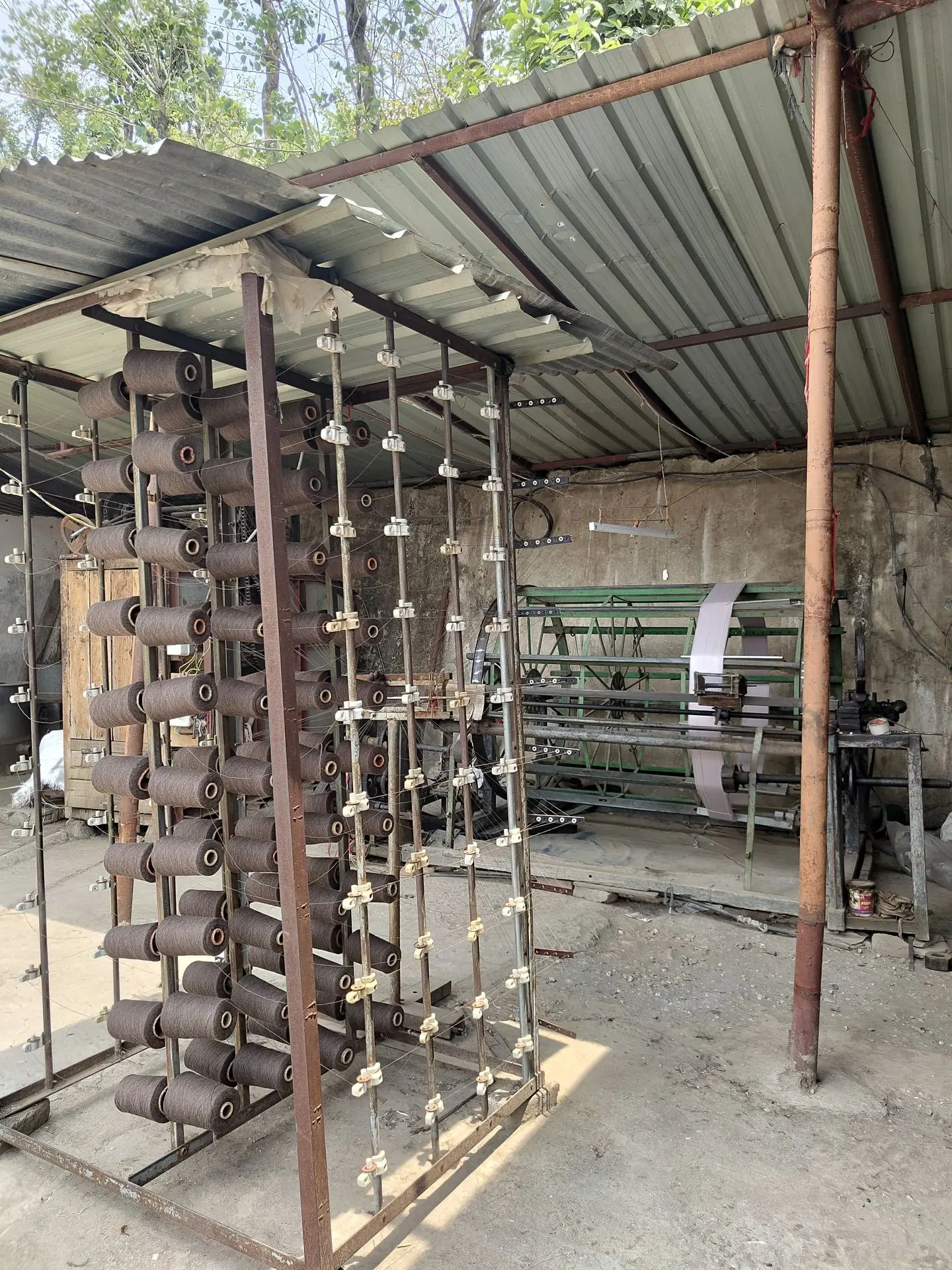 Wool yarn cones loaded on creel in Sawomi handloom unit