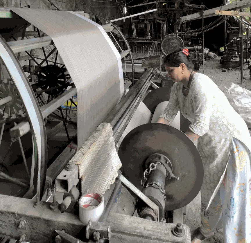 Traditional artisans aligning wool threads on warping frame